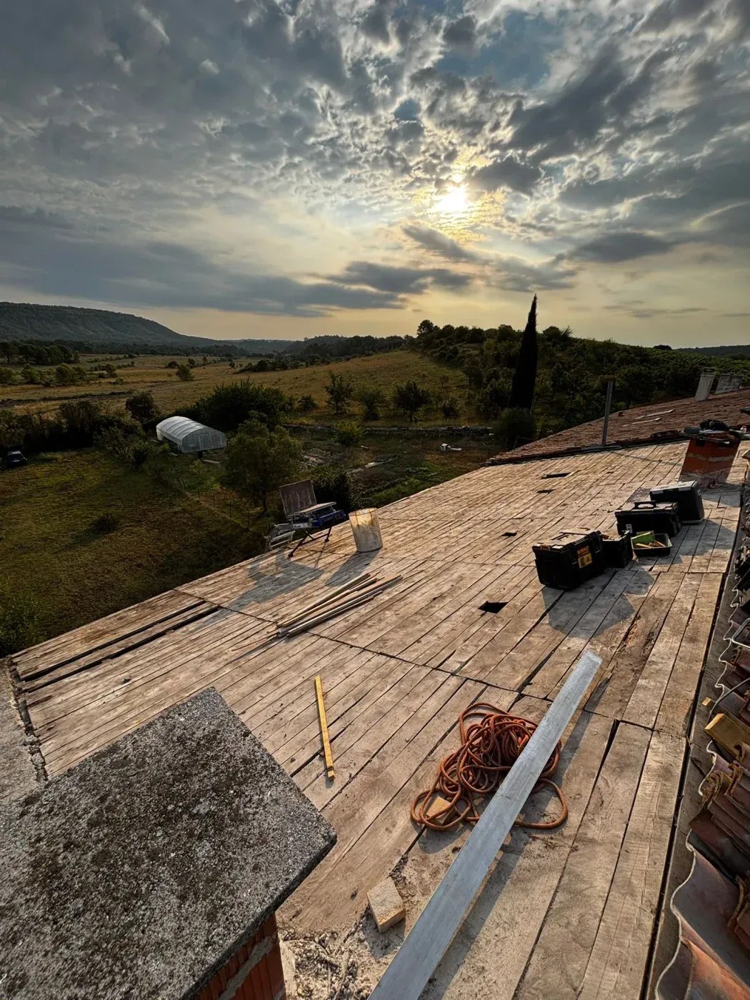 Chantier de charpente en fin de journée, dans la garrigue